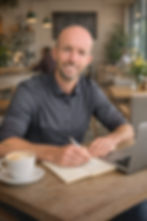 James Isaacs working on a laptop in a café, website strategist and copywriter at Ostix Consulting