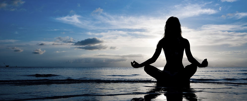 woman on beach at sunrise meditating