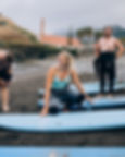 Surf instructor Magdalena, beaming with her signature smile, prepares for a lesson on Alagoa Beach in Porto da Cruz with eager students.