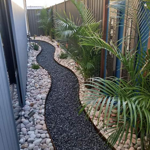 Path defined by 100mm straightcurve edging with river stone and black bassalt,