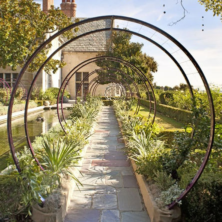 Steel moon gate arbour creating circular garden entrance feature