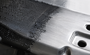 Partially stripped coating revealing clean metal during surface restoration