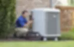 AyrSmith technician servicing a residential air conditioning unit for reliable cooling performance