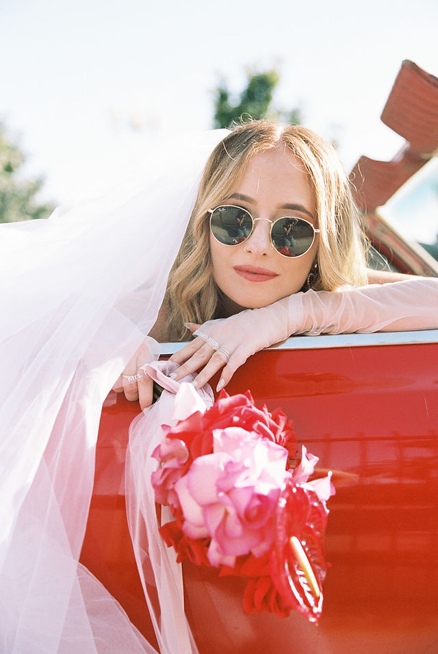 35mm film photo by las vegas elopement photographer brazen honey films. couple takes pictures with cherry red vintage convertible