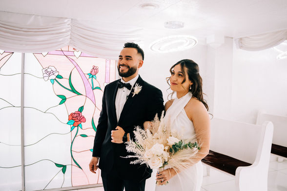 Bride and groom hold hands during their wedding ceremony at the little white wedding chapel. Captured by las Vegas elopement photographer brazen honey films.
