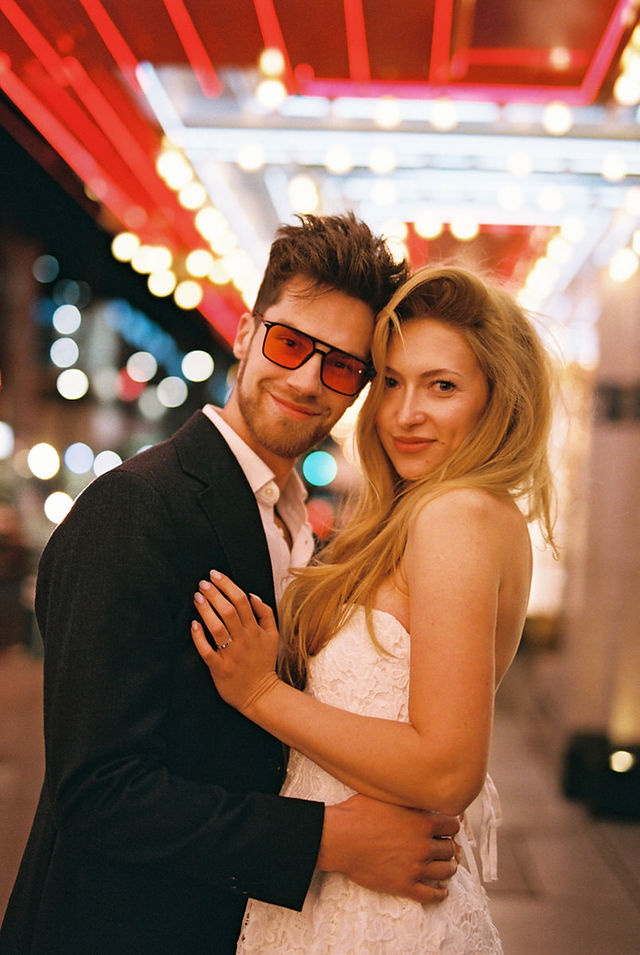 bride and groom wearing formal attire embrace each other outside of the little white wedding chapel in las vegas