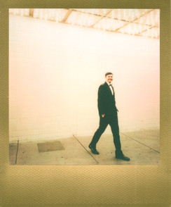 Gold border polaroid picture of groom under the neon lights at the plaza hotel on fremont street. Captured in downtown las vegas by vegas elopement photographer brazen honey films. 