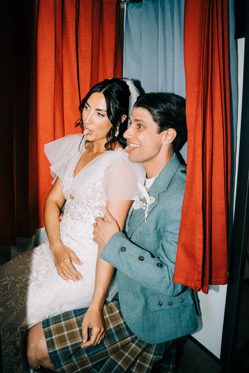 Bride and groom take photos in the vintage photo booth at the sure thing chapel. Captured by las vegas elopement photographer brazen honey films.