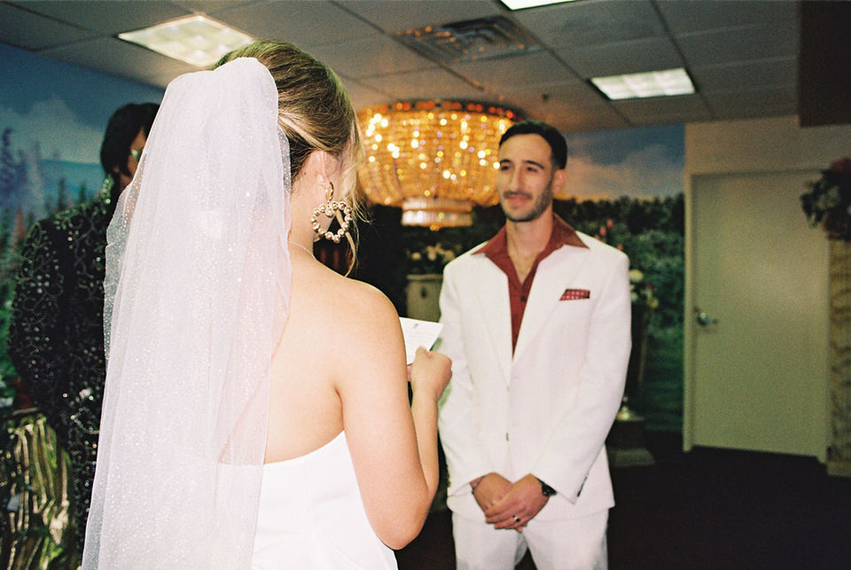 Kitsch elopement at the little white wedding chapel in las vegas shot on 35mm film. Neon lights wedding portraits by wedding photographers brazen honey films