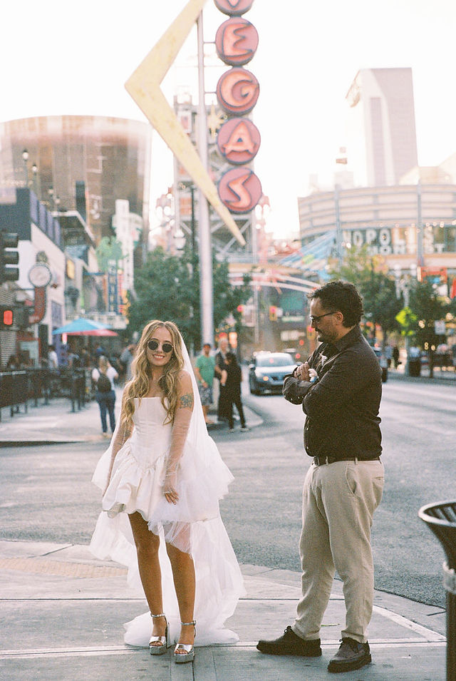 35mm film photo by las vegas elopement photographer brazen honey films. couple takes pictures in downtown las vegas with neon lights and vintage vibes.