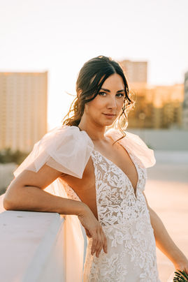 Bride and groom pose for pictures in downtown las vegas at golden hour with the strip in the background. captured by las vegas wedding photographer brazen honey films. Groom wears stylish stottish kilt. Bride wears custom made with love bridal gown.
