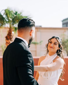 Bride and groom share first look in downtown Las Vegas. Bride wears halter top white mini dress and smiles at her husband. captured by Las Vegas wedding photographer brazen honey films