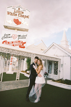 bride and groom wearing formal attire embrace each other outside of the little white wedding chapel in las vegas