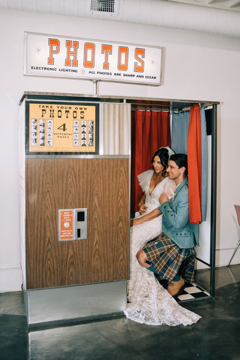 Bride and groom take photos in the vintage photo booth at the sure thing chapel. Captured by las vegas elopement photographer brazen honey films.