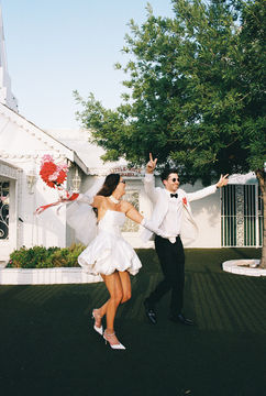 Las Vegas film photographer brazen honey films captures couple from New Zealand who got married at the little white wedding chapel. Bride wears short white gown with red and pink florals from Lucid Juliet. 35mm film photos.