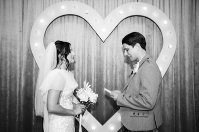 Bride & Groom stand at the altar of the sure thing chapel and read their vows in front of the heart altar. Black and white photograph. Captured by las vegas elopement photographer brazen honey films