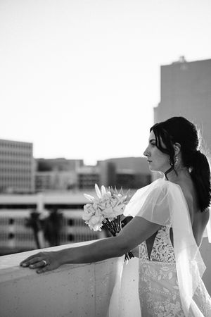 Bride and groom pose for pictures in downtown las vegas at golden hour with the strip in the background. captured by las vegas wedding photographer brazen honey films. Groom wears stylish stottish kilt. Bride wears custom made with love bridal gown.