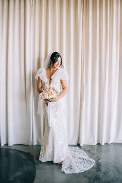 Bride poses for photos at the sure thing chapel wearing beautiful lace dress with bridal cape. Groom stands at the altar at the sure thing chapel waiting for his bride. Captured by las vegas elopement photographer brazen honey films