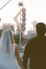 35mm film photo by las vegas elopement photographer brazen honey films. couple takes pictures in downtown las vegas with neon lights and vintage vibes.