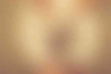 A couple in formal attire joyfully holds hands walking under glowing lights. Background: tiled wall, warm ambiance.