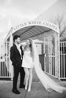 black and white photograph of couple wearing forma attire outside the little white chapel in las vegas