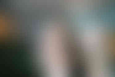 bride and groom stand at altar and smile with murals and chandeliers behind them at the little white chapel