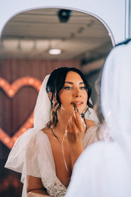 Bride applies lipstick in the mirror at the sure thing chapel. Captured by las vegas elopement photographer brazen honey films
