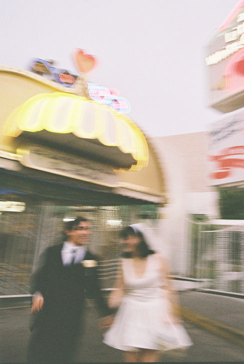 bride and groom wearing wedding attire take photos outside of the little white wedding chapel in las vegas 
