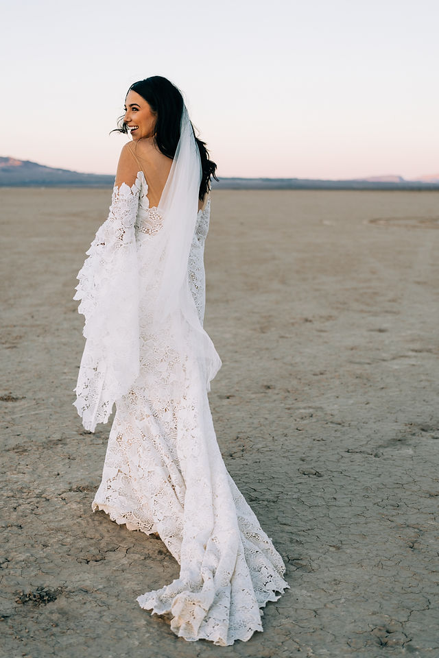 Bride wears lace dress with bell sleeves for her boho inspired desert elopement in Las Vegas, captured by Las Vegas wedding photographer brazen honey films 