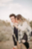 Beautiful couple hugging and kissing in the desert at sunset, captured by las vegas wedding photographer hayway films. Adventurous engagement photography in Joshua Tree National Park.