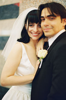 bride and groom wearing wedding attire smile and hug