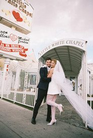 bride and groom wearing formal attire embrace each other outside of the little white wedding chapel in las vegas