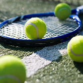 close-up-tennis-racket-balls-ground.jpg