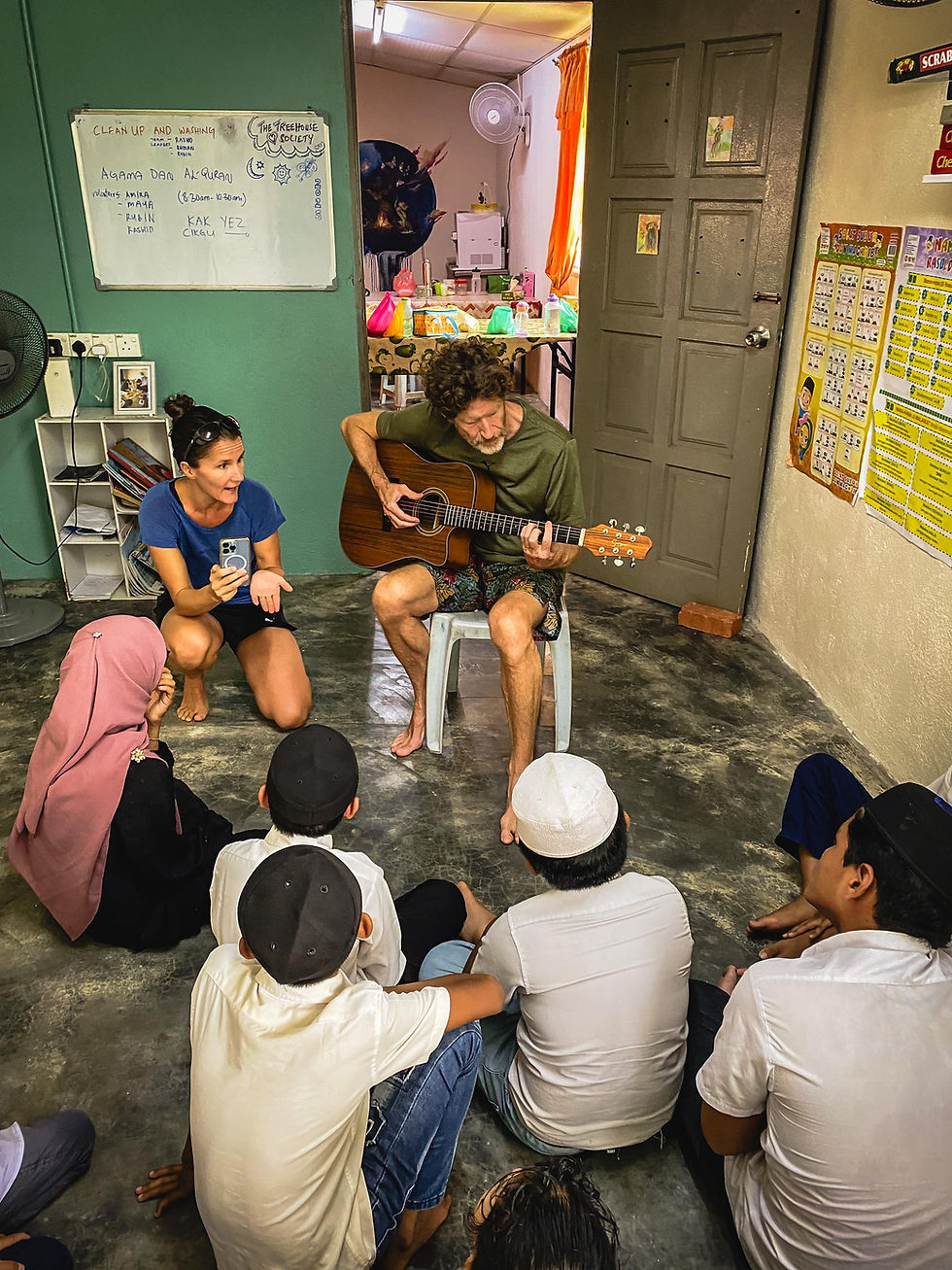 Showing the children how to play guitar