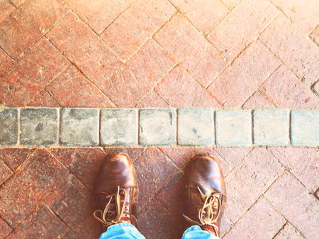 Schuhe, die vor einer Linie stehen / Grenzen setzen