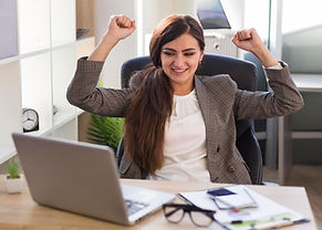 femme-d-affaires-victorieuse-au-bureau-avec-ordinateur-portable.jpg