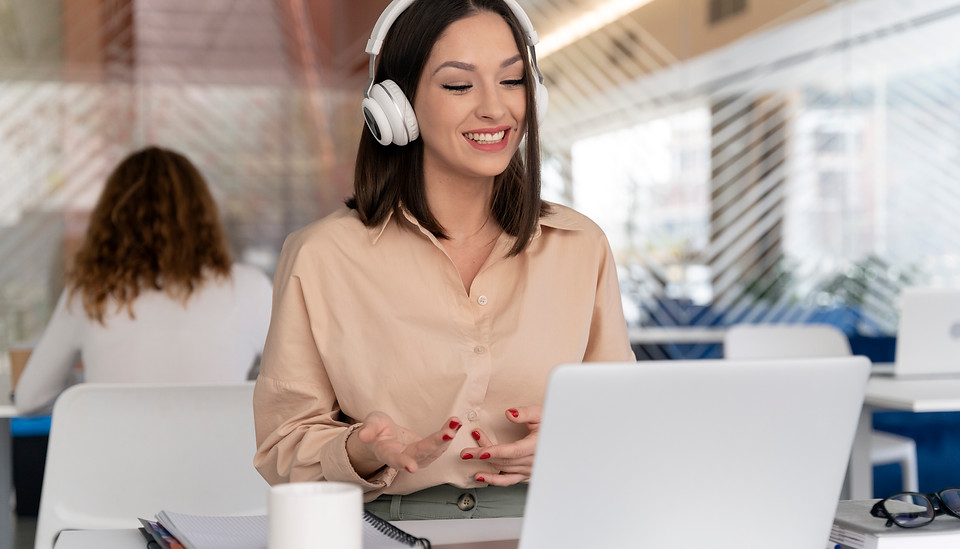mulher-de-negocios-jovem-trabalhando-no-escritorio-com-laptop-e-fones-de-ouvido.jpg