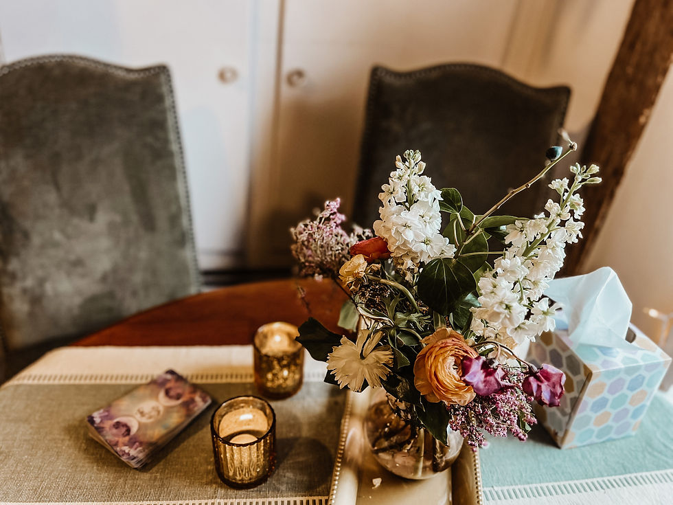 Comfy chairs at a beautifully set table ready for a Tarot Reading.