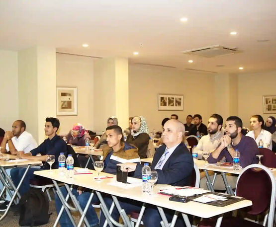 حضور محاضرة، مجموعة من الأشخاص يستمعون، طاولات، تسجيل الماجستير المصغر، مؤسسة صُناع القرار