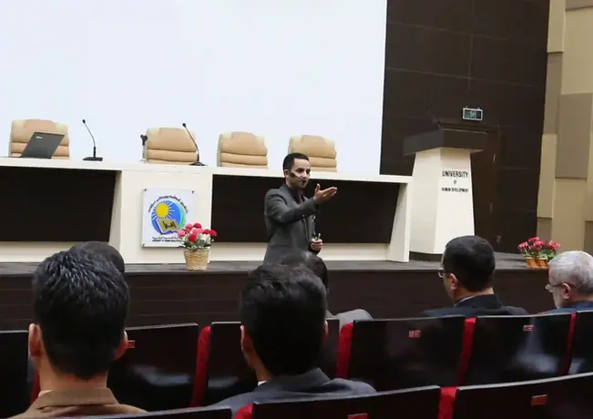 رجل يتحدث على المسرح أمام الجمهور في قاعة محاضرات مؤسسة صُناع القرار.