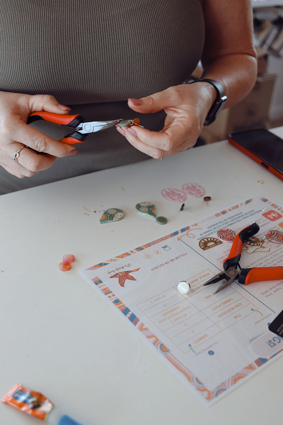 a lady constructing a pair of earrings at a little black duck workshop