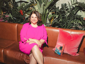 Samantha Murphy sitting on a couch with a red pillow