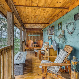 deck with furniture, and decorated turquoise colored wall and fire table.