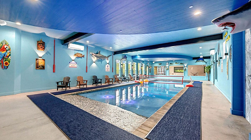 Large indoor swimming pool with chairs around.