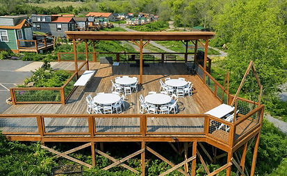 Wedding or other group venue for a tiny home community of vacation cabins in Sevierville, Tennessee, with deck and tables outdoors.