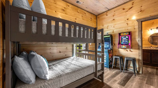 bunk beds and arcade games in cabin rental bedroom