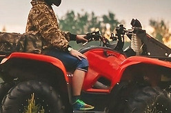 A person sits on an ATV, all terrains vehicle rider