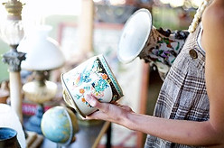 woman looks at vintage and antique items for sale at a store.