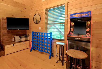 tv, game and arcade near a window in a treehouse style cabin in Pigeon Forge, Tennessee