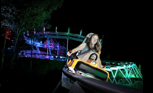 Person rides the Rocky Top Mountain Coaster at night